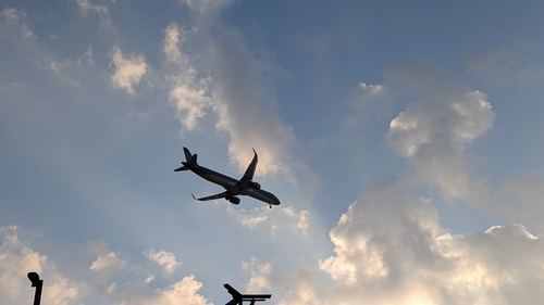 街の上を低空で飛ぶ飛行機。